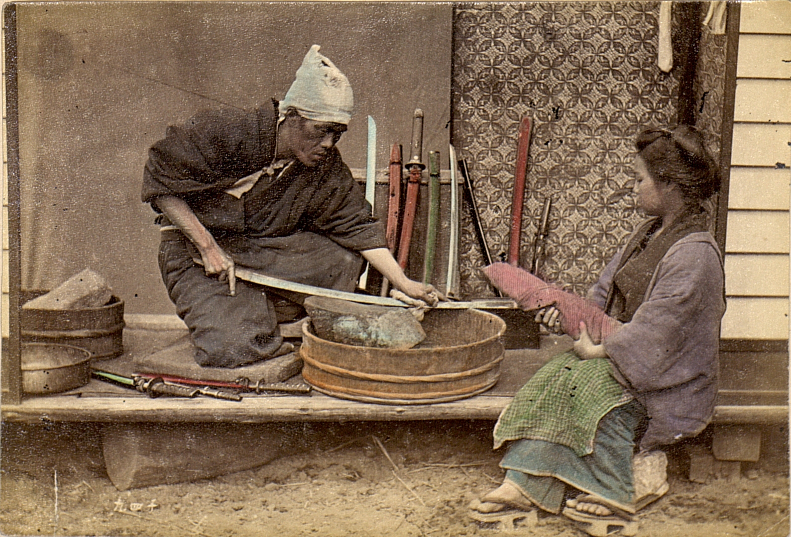 Um polidor de espada japonês afiando uma lâmina em 1909