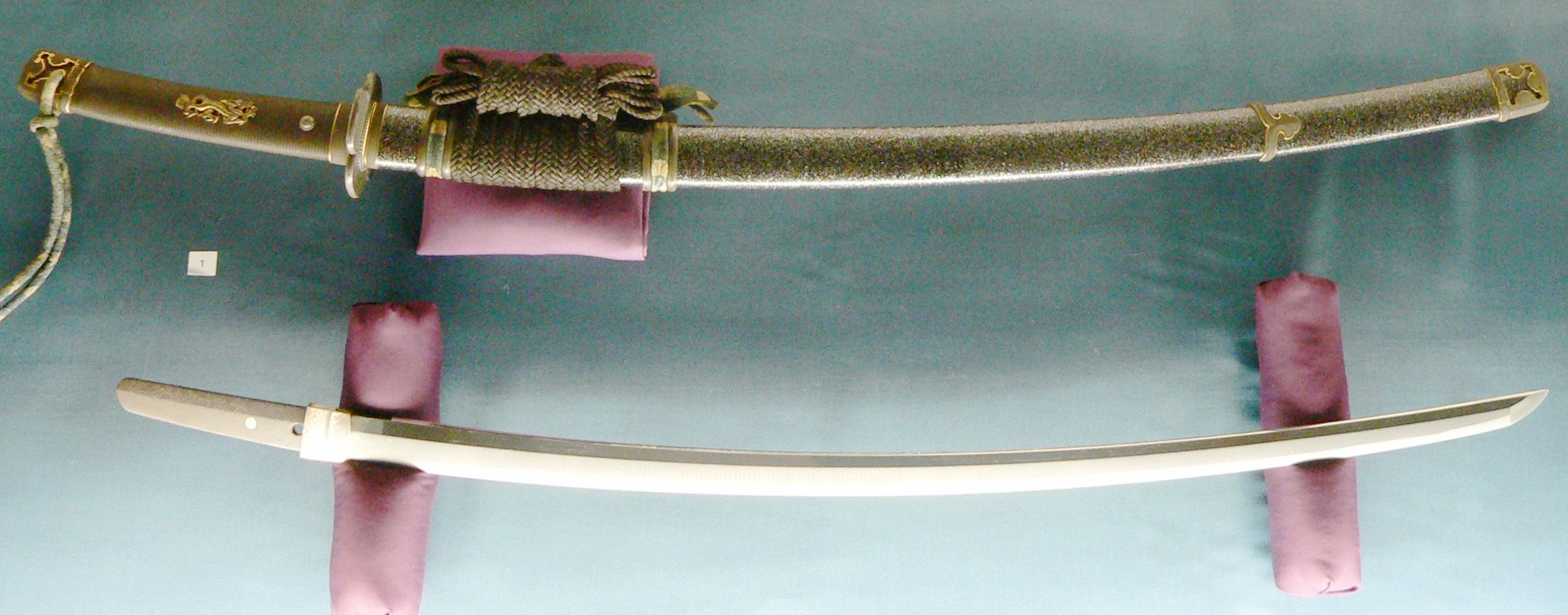 Antiga espada tachi japonesa exibida em um suporte de madeira